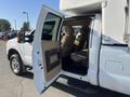 A 2014 Ford F-350 SD with its driver side door open revealing a tan interior and spacious seating in the cab