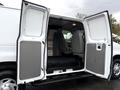 A 2006 Ford Econoline van with open double doors revealing two front seats and a spacious cargo area behind them