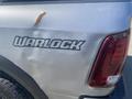 A silver 2021 RAM 1500 with a visible Warlock decal on the side and a small rust spot near the decal