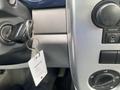 A 2007 Chrysler PT Cruiser's ignition key is inserted in the ignition switch with a key tag attached sitting on the dashboard next to the control panel