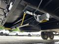 A close-up of the undercarriage of a 2022 Heartland Torque showing a tire mounted underneath a trailer with a motor and support brackets visible