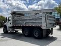A 2010 Freightliner M2 106 dump truck with a silver metal dumper body and dual rear wheels is shown from the side