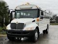 A white 2016 International CE300 school bus with visible headlights and side lights is parked facing forward showcasing its large windows and front grille design