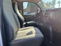 Interior view of a 2013 Chevrolet Express showing two front seats with gray fabric upholstery and a center console between them