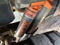 Close-up of a FOX Live Valve shock absorber attached to a 2019 Ford F-150 showcasing its orange and black branding with a textured surface and a tire visible in the background