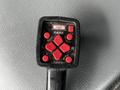 A black and red control panel with buttons labeled for raising lowering and scooping features, featuring directional buttons and an on/off switch