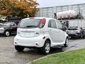 A white 2013 Mitsubishi i-MiEV parked with its rear view visible showcasing its compact design and distinctive taillights