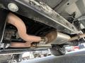 The underside of a 1962 Ford F-100 showing the exhaust system with a silver muffler and curved pipes