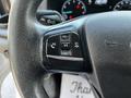 Close-up of the steering wheel controls of a 2021 Ford Transit featuring buttons for volume and hands-free calling