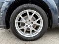 Silver alloy wheel of a 2013 Dodge Journey with a black tire and visible lug nuts