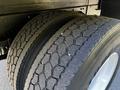 Close-up of a pair of rear tires from a 2021 Hino 338 showcasing deep tread patterns and robust rubber texture