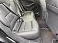 Interior view of the rear seating area of a 2016 Mercedes-Benz GLA-250 featuring black leather seats with seatbelts