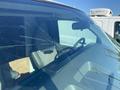 A 2012 GMC Savana with a cracked windshield visible in the foreground