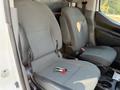 Two grey fabric front seats of a 2021 Nissan NV200 with a pair of keys resting on the center console between them