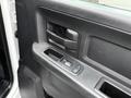 Close-up of the door handle and window control panel of a 2013 RAM 3500 truck interior