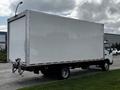 A 2019 Hino 195 box truck with a large white cargo area and metal frame parked on a street