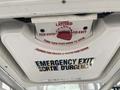 A ceiling hatch labeled as an emergency exit with instructions in English and French for opening it