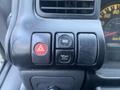 Close-up of the dashboard control panel of a 2007 GMC W5500 featuring hazard light button odometer reset button and oil pressure warning light button