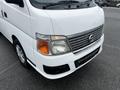 A white 2002 Nissan Van featuring a chrome front grille and distinct headlights