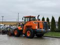 A 2018 Doosan DL300-5 wheel loader in orange color with large tires and a front bucket attachment