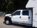 A 2012 Ford F-550 truck with a white exterior featuring a side view and visible specifications on the door