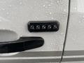 A close-up of a keypad entry system on the driver's side door of a 2018 Ford Transit with water droplets on its surface