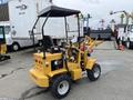 A yellow 2024 AGT Industrial KRW23 Mini Loader with a raised engine cover and a small front loader attachment on the front