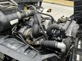 A 2006 Hino 268 engine showing various components including hoses pipes and an alternator in a close-up view