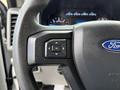 Close-up of the steering wheel of a 2017 Ford F-450 Super Duty showing the Ford logo and control buttons for navigation and settings