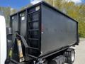 2009 Ford LCF 550 truck with a large black dump body featuring a ladder and safety labels on the side