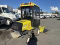 A 2010 Kubota F3990 with a yellow cabin and mower attachment, featuring large wheels and a compact design, positioned on a gravel surface