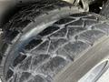 Close-up of a rugged tire with deep treads showing signs of wear and dirt on a 2010 Freightliner M2 106