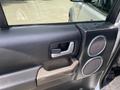 Close-up of the interior door handle and speaker of a 2006 Land Rover LR3 showcasing a combination of silver and black detailing