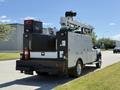 A 2023 Ford F-550 service truck with a raised aerial lift and storage compartments on the back