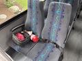 A 2020 Chevrolet Express with a seat featuring blue and teal wave patterns a black helmet and a red fire extinguisher are placed on the seat