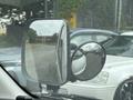 A 2009 Toyota Hiace with side mirrors reflecting nearby vehicles and surroundings