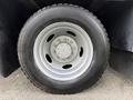 Close-up of a black tire and wheel of a 2008 Ford F-450 showing a five-lug pattern and visible tread detail