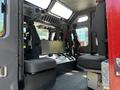 Interior of a 2006 Emergency One Fire Truck featuring gray seats and a control panel with various controls and equipment