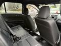 A 2019 Ford Explorer interior showing the back seat area with two seats and seat belts in black upholstery