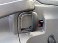 Close-up of a door handle on a 2020 Chevrolet Express with a black lever and a small red button next to it