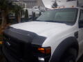 A white 2008 Ford F-550 with a black front grille and hood protector visible in the foreground