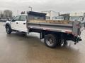 2021 Ford F-550 with a flatbed truck body showing a silver trailer bed and a black chassis positioned at an angle