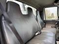 Interior view of a 2011 International 4300 featuring a three-person bench seat with black leather upholstery and seatbelts