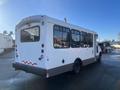 A white 2012 Chevrolet Express with large windows and a high roof designed for passenger transport