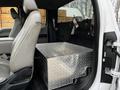 A 2016 Ford F-150 with a silver diamond plate storage box installed in the rear seating area and a single front seat visible