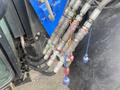 A close-up view of hydraulic hoses and fittings connected to a 2016 New Holland T475 tractor showcasing various colored connections
