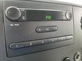 Dashboard of a 2009 Ford Econoline featuring a radio display with buttons for volume tuning and station selection
