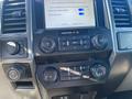 Dashboard of a 2019 Ford F-150 featuring controls for audio and climate settings along with a display screen for settings and diagnostics