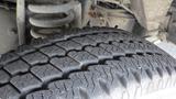 A close-up of a tire from a 2011 Ford Econoline showcasing its detailed tread pattern and sidewall design