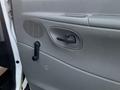 A close-up of the interior door panel of a 2008 Ford Econoline featuring a door handle and a manual window crank